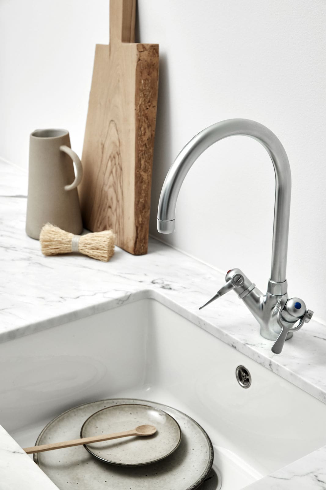 Sølv armatur med hvid vask og marmorplade