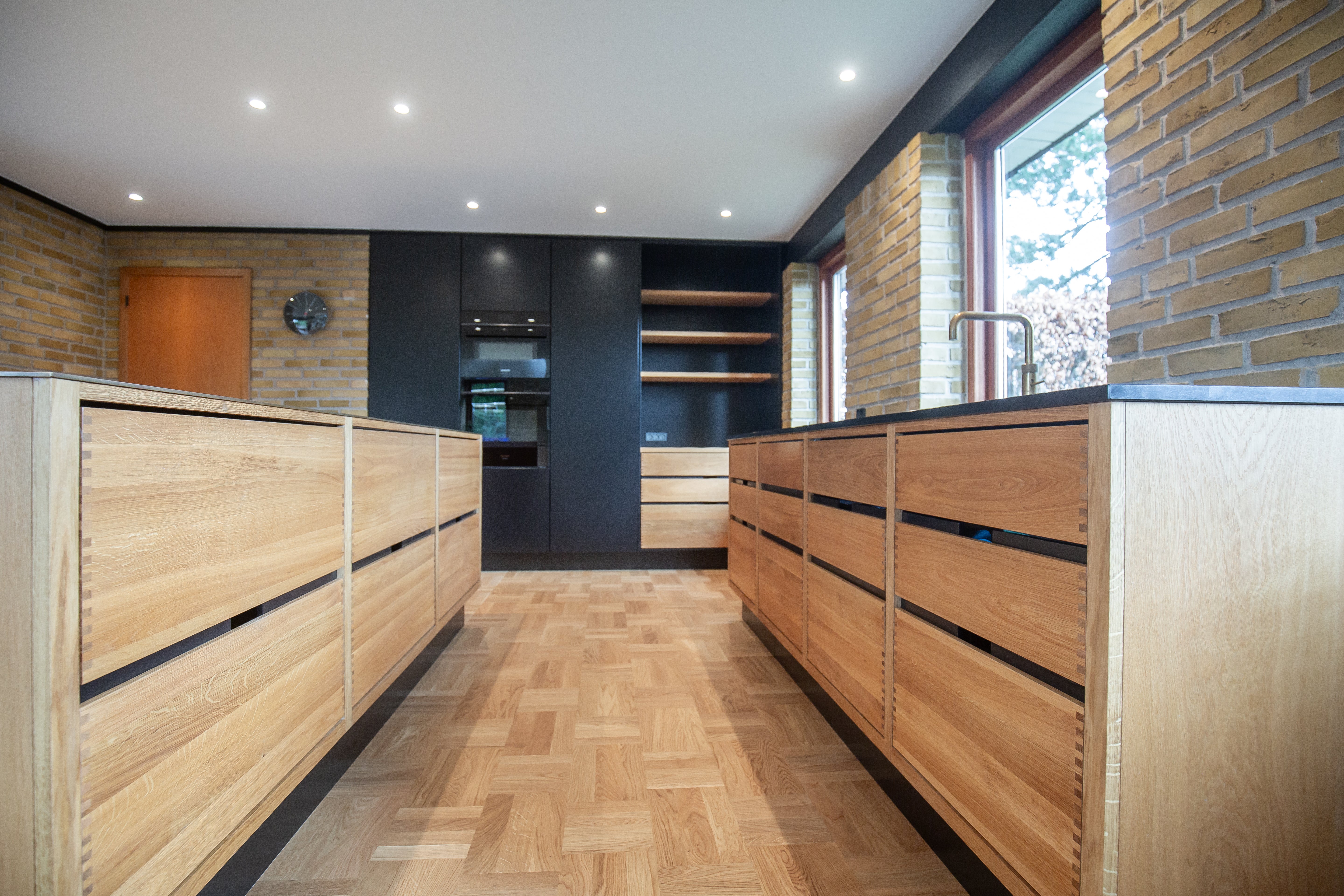 Fingertappet egetræskøkken med sorte indbygget højskabe