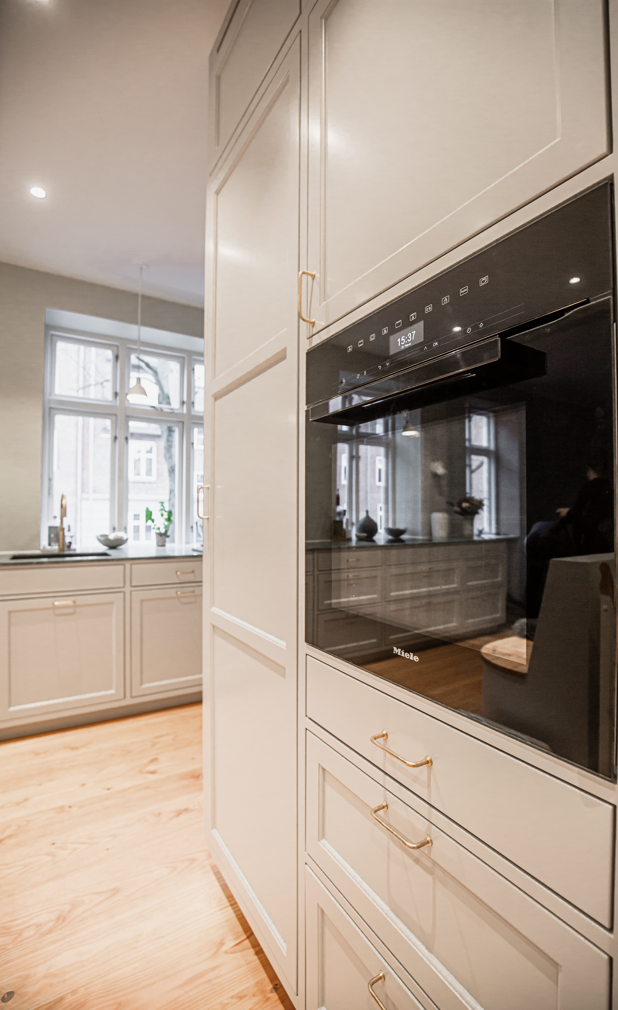 Hvidt snedker køkken med integreret hvidevarer
